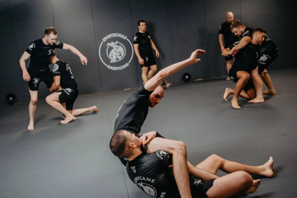 Grappling-Training bei Harrycane Luta Livre: Mehrere Paare üben Techniken auf der Matte in der Sportschule.