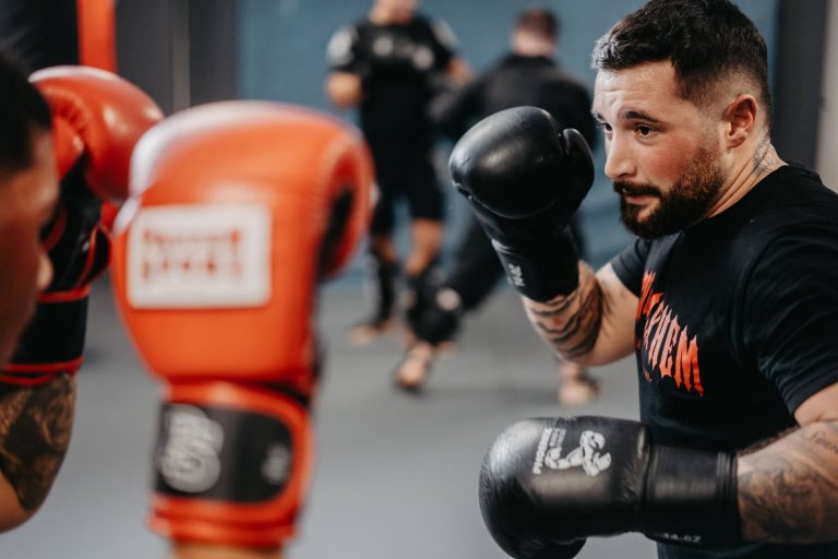 Über uns 11 Intensives Sparring beim Boxtraining in der Sportschule Harrycane, fokussierter Athlet mit schwarzen Handschuhen.