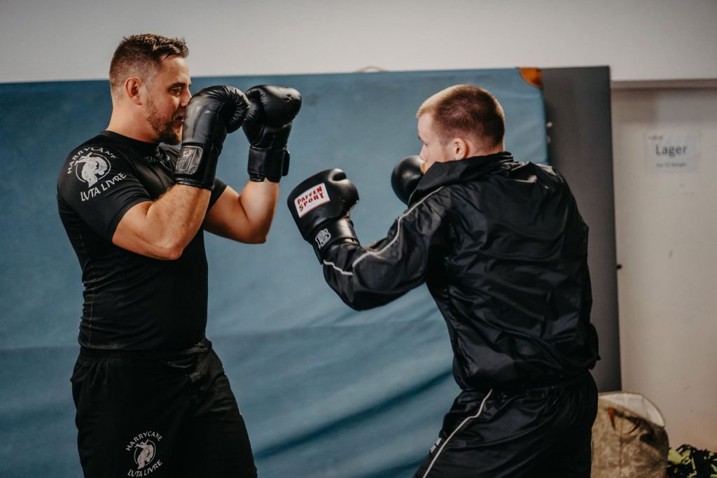 Zwei Männer trainieren Boxtechniken mit Fokus auf Präzision und Verteidigung in der Sportschule Harrycane in Herford.