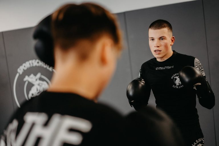 Über uns 12 Zwei Jugendliche beim MMA-Training in der Sportschule Harrycane in Herford, konzentriert mit Boxhandschuhen.